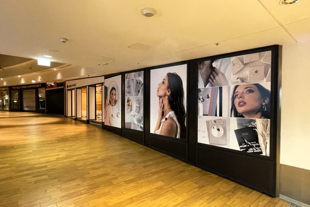 reklamni posteri na izlogu dućana u trgovačkom centru